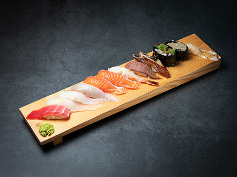 Different types of sushi on a wooden plate