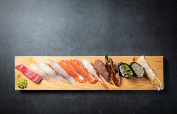 istock Different types of sushi on a wooden plate 1755164348