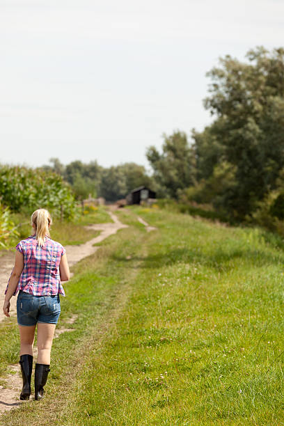 istock Young woman walking up a dirt road 175516959