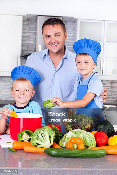 Padre Con Sus Hijos En La Cocina Para La Cena Foto de stock y más banco de imágenes de 4-5 años - 4-5 años, Adulto, Alegre