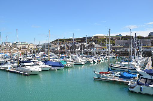The marina at St Helier, the capital of Jersey. Logos and names removed from boats. Any flags are nautical standards or country identifications.