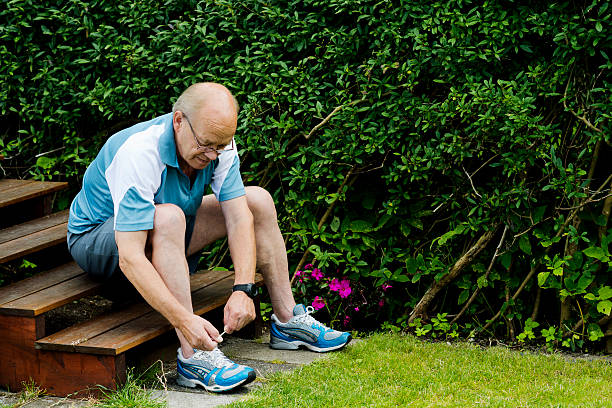 Senior man is tying a sports shoe before running