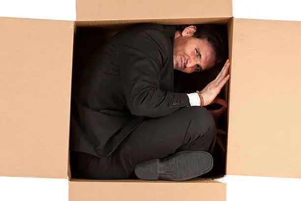 Businessman in a cardboard box
