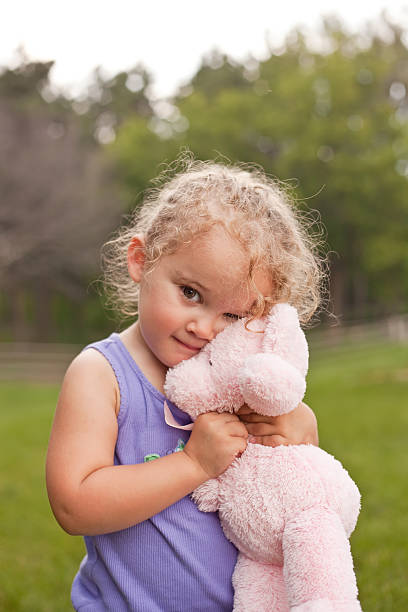 istock Girl Hugging Pink Teddy Bear 175518567