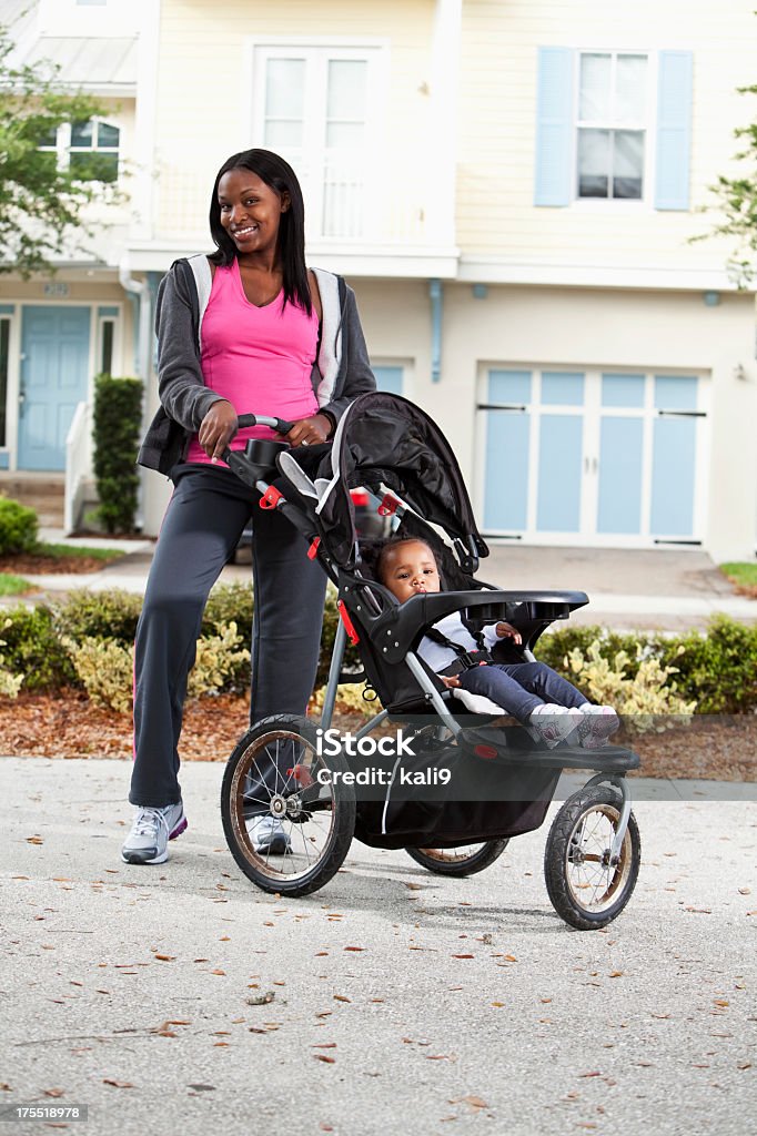 Afroamericano madre con bambino nel Passeggino a tre ruote - Foto stock royalty-free di Madre