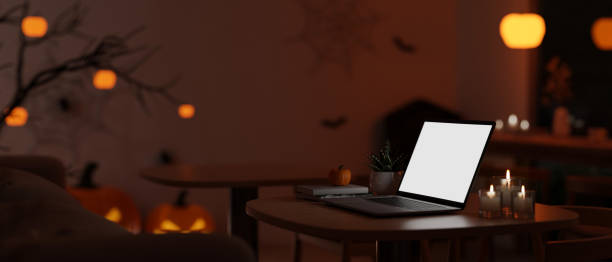 istock A white-screen laptop mockup on a table in a dark room decorated with a Halloween theme. 1755194161