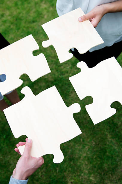 istock People hold large jigsaw pieces that symbolize teamwork 175519540