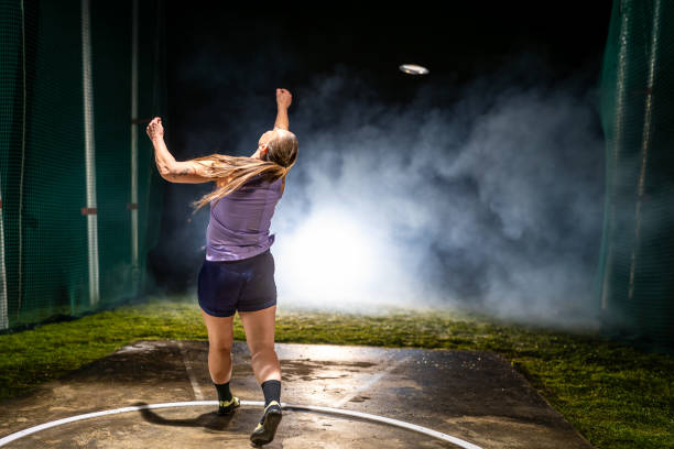 istock Woman throwing discus at night 1755196966