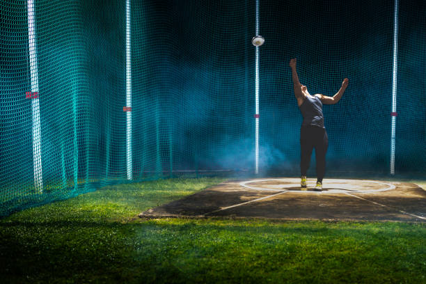 Young athlete practicing javelin-throwing technique on sports field with focus and precision. Open area and stadium backdrop create a dedicated training environment