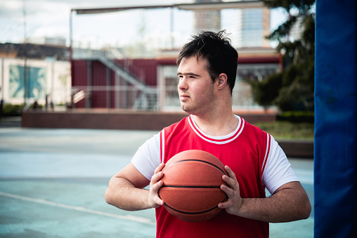 Man plays basketball on the basketball court outside