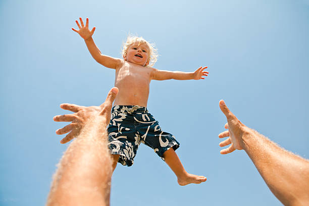 istock Cheerful father playing with his young son at the beach 175519832