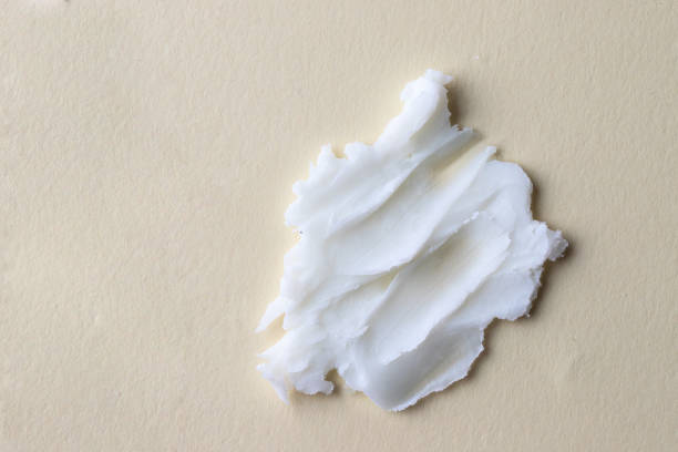 White creamy texture of clean cleansing butter on beige background.Cosmetic swatch White creamy texture of clean cleansing butter on beige background.Cosmetic swatch theobroma stock pictures, royalty-free photos & images