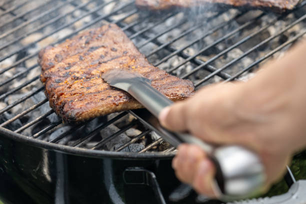istock Pork ribs on a grill being handled with tongs 1755200429