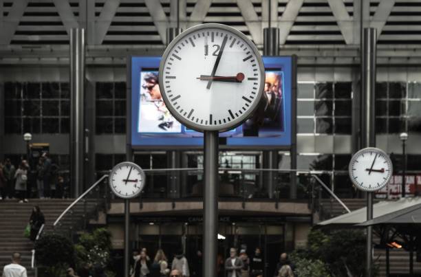 viele menschen gehen in der nähe von six public clocks reuter plaza spazieren. gruppieren sie eine der uhren auf den masten. - concepts and ideas travel locations architecture and buildings time stock-fotos und bilder