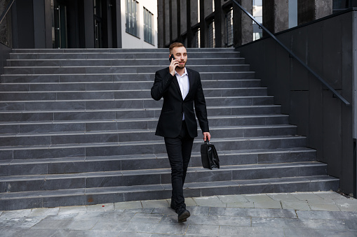 businessman walking downstairs in an office park with a tablet in the hand