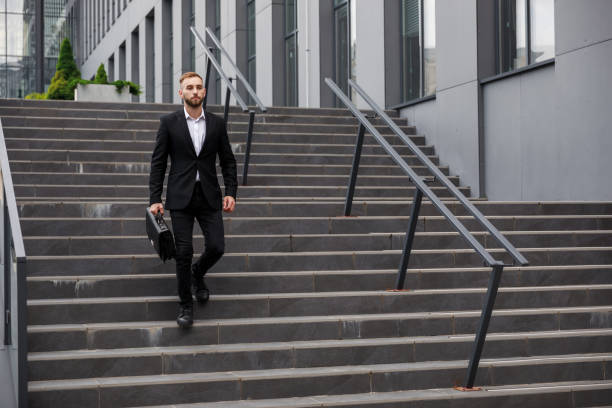 istock A young man in strict clothes with a bag in his hands goes down 1755205137