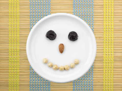 Face Made By Dried Fruits And Nuts In  White Plate