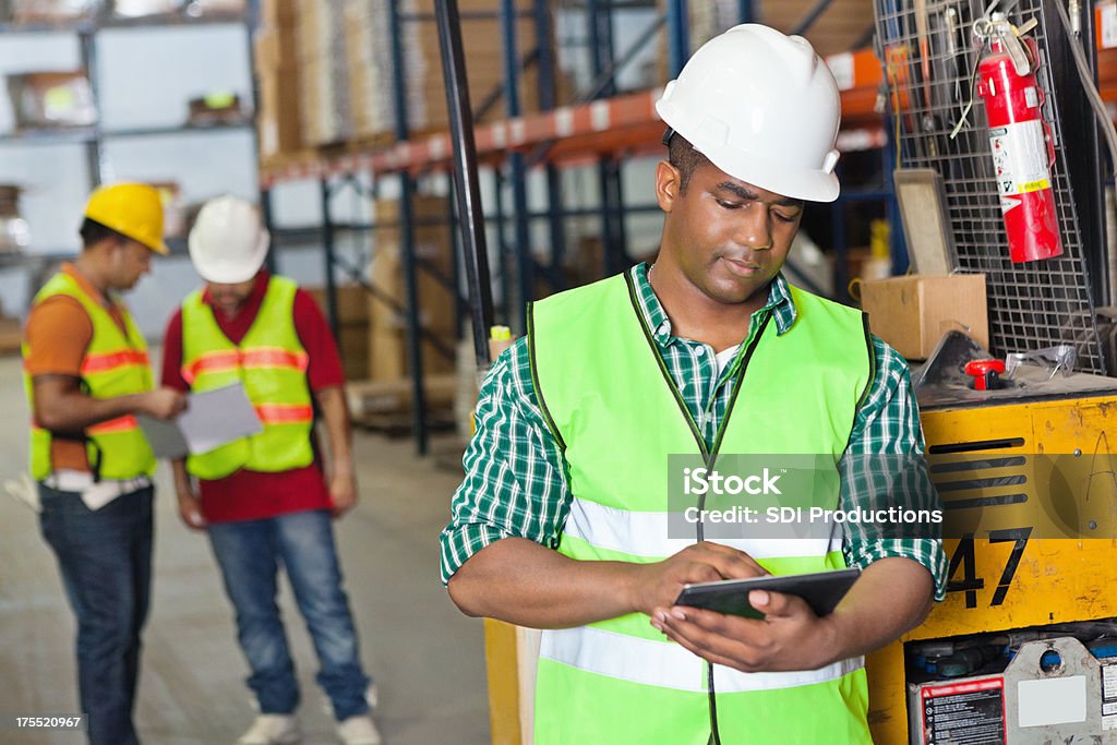 Trabajador almacén utilizando tableta digital de inventario de productos - Foto de stock de Accesorio de cabeza libre de derechos