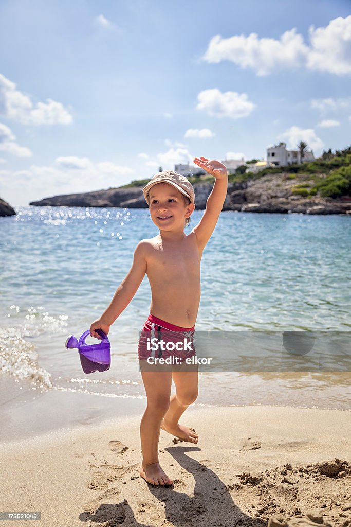 Happy Little Boy Saludar con la mano en la playa - Foto de stock de Bañador de natación libre de derechos