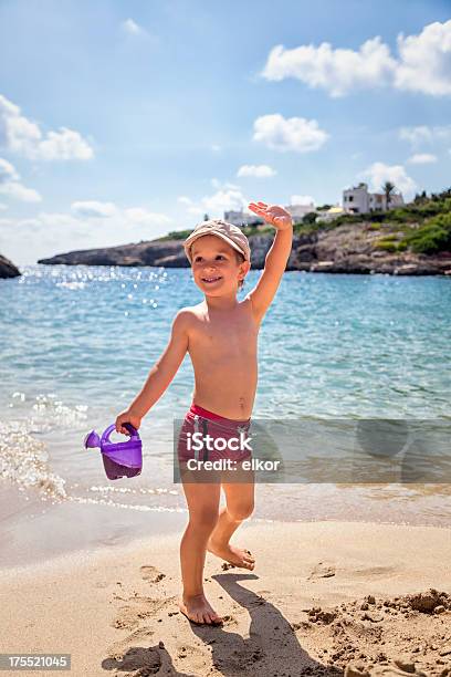 Photo libre de droit de Petit Garçon Heureux Agitant Sur La Plage banque d'images et plus d'images libres de droit de Short de bain - Short de bain, Petits garçons, Activité de loisirs