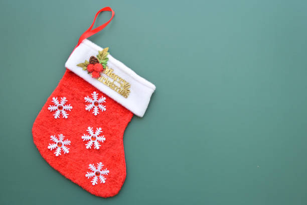 istock red wool winter sock on green background, christmas decoration 1755213107