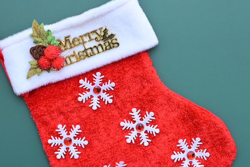 red wool winter sock on green background, christmas decoration