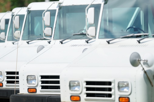 Close up of postal delivery trucks parked in a line.
