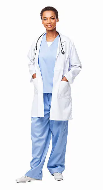 Full length portrait of a confident African American female healthcare worker standing with hands in pockets. Vertical shot. Isolated on white.