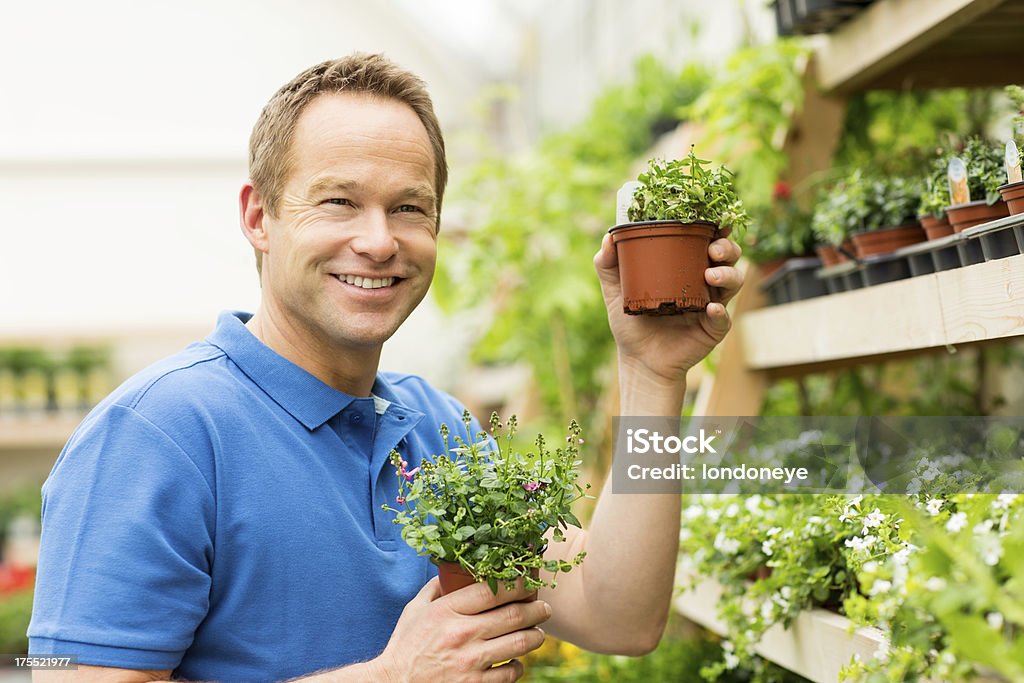 Uomo con piccole piante in vaso - Foto stock royalty-free di Abbigliamento casual