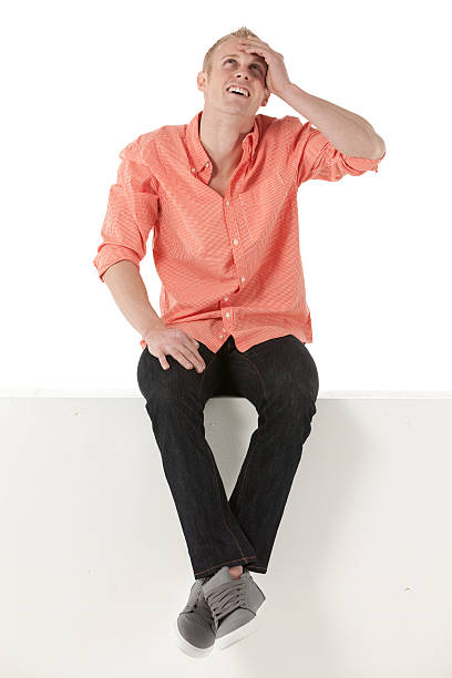 istock Man sitting on the ledge of a wall and looking up 175522465