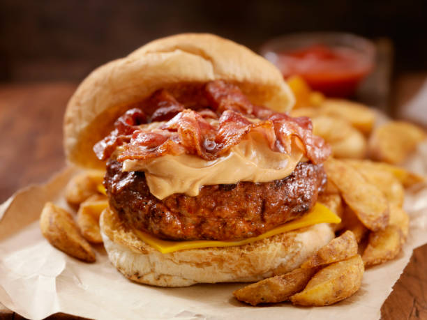 Peanut Butter Bacon Burger Peanut Butter Bacon Burger on a toasted Kaiser Bun with Wedge cut French Fries-Photographed on Hasselblad H3D-39mb Camera bacon cheeseburger stock pictures, royalty-free photos & images