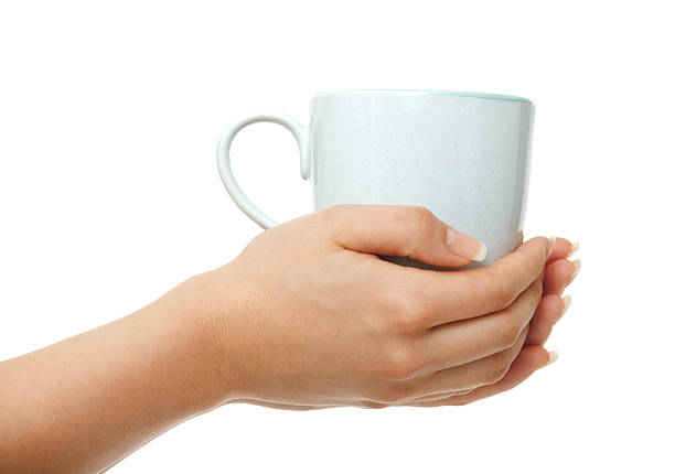 Woman hands holding coffee mug on white