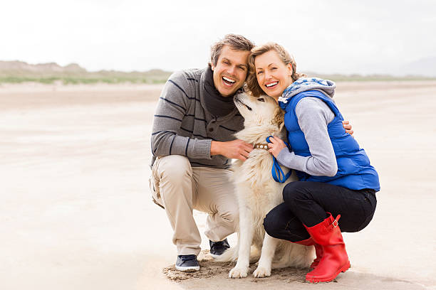 istock Cheerful Couple With Dog On Beach 175523685