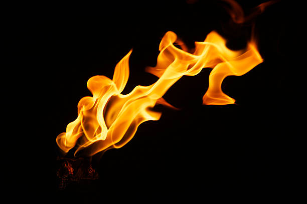 chama grande plano em um bastão fundo preto - flaming torch fire flame sport torch imagens e fotografias de stock
