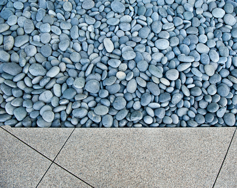 An arrangement of smooth river rocks encased in poured concrete in the public area of a corporate skyscraper.