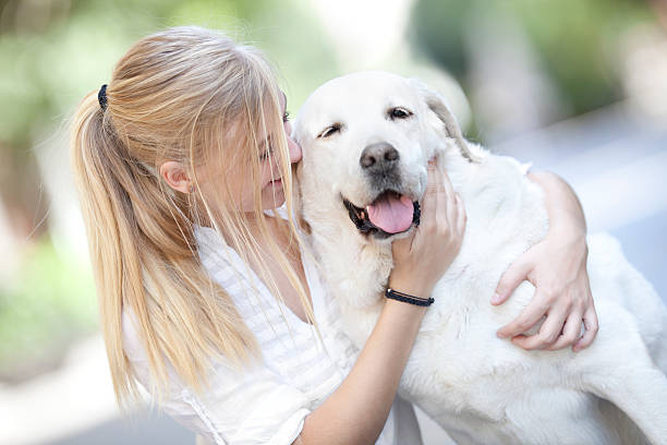 istock girl embracing white labrador 175524656