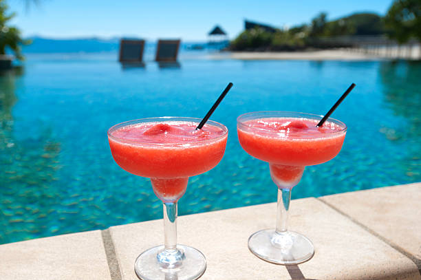 2 cocktails an einen resort-swimmingpool - strawberry daiquiri stock-fotos und bilder
