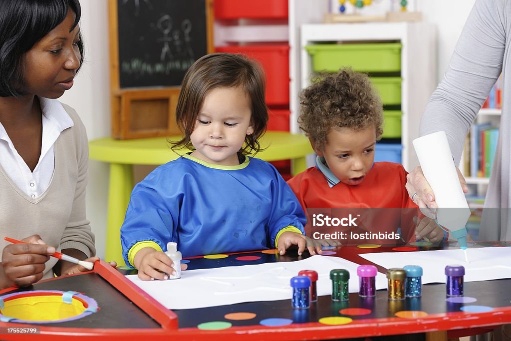 Toddler/ Little Boy Excited By Carer Squeezing Glue A portrait of a toddler/ litte boy excited by carer squeezing out glue. Glue Stock Photo