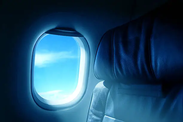 close up interior shot of airplane seat by window.