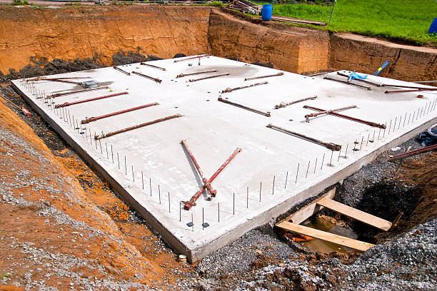 Concrete Slab for a new Home "Concrete foundation, floor of the basement for a new home, reinforcing steel on the edges for installation of precast concrete walls, on ground lying pillars to keep the walls up to the final assembly." solid stock pictures, royalty-free photos & images