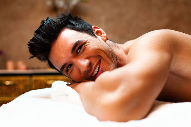 homme sur une table de massage - massage sensuel photos et images de collection