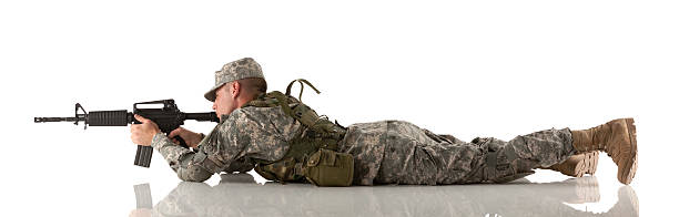 Military man lying on the floor and aiming with a