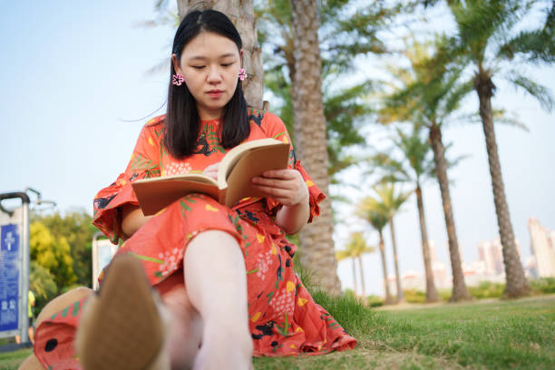 woman sitting in park reading book