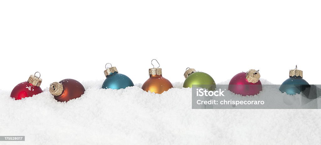 Christmas Baubles in Snow Colorful Christmas baubles sitting in the snow. Christmas Stock Photo