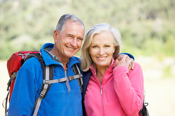 portret senior para na piesze - senior couple senior adult walking action zdjęcia i obrazy z banku zdjęć