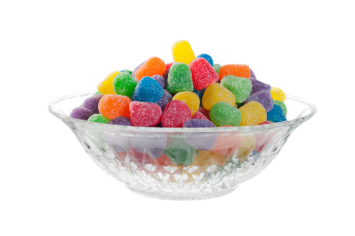 Multicolor small mixed colored chocolate coated candies in bowl, isolated on white.