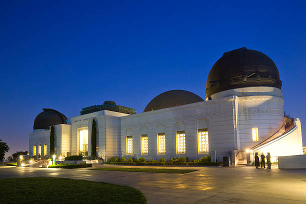 Griffith Park Observatory "The Griffith Park Observatory building in Los Angeles in the evening. Long exposure, some people in motion." griffith park observatory stock pictures, royalty-free photos & images