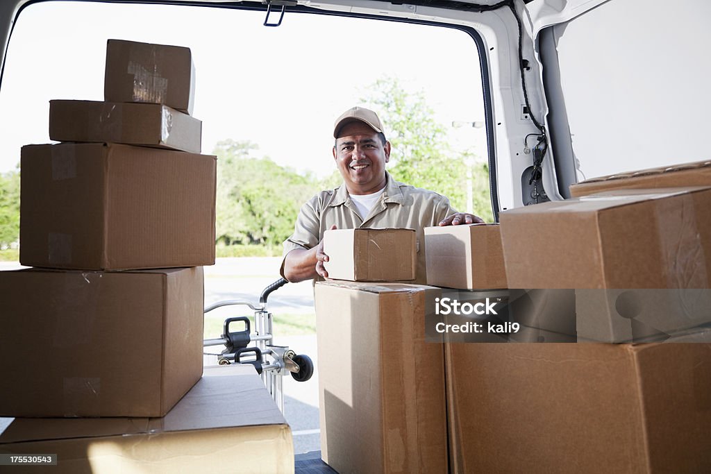 Hispanic man delivering packages Hispanic man (40s) delivering packages, view from inside delivery van. 40-44 Years Stock Photo