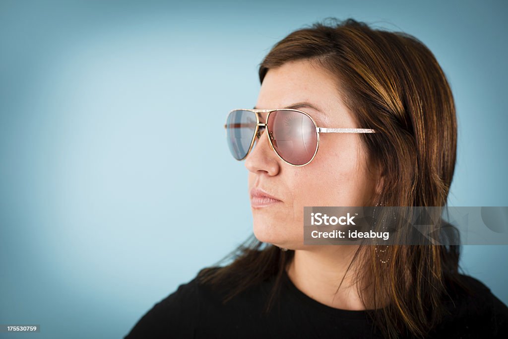 Woman Modeling Vintage Sunglasses, With Copy Space "Color image of a woman wearing a pair of vintage sunglasses, with turquoise background. Includes room for your text." 25-29 Years Stock Photo