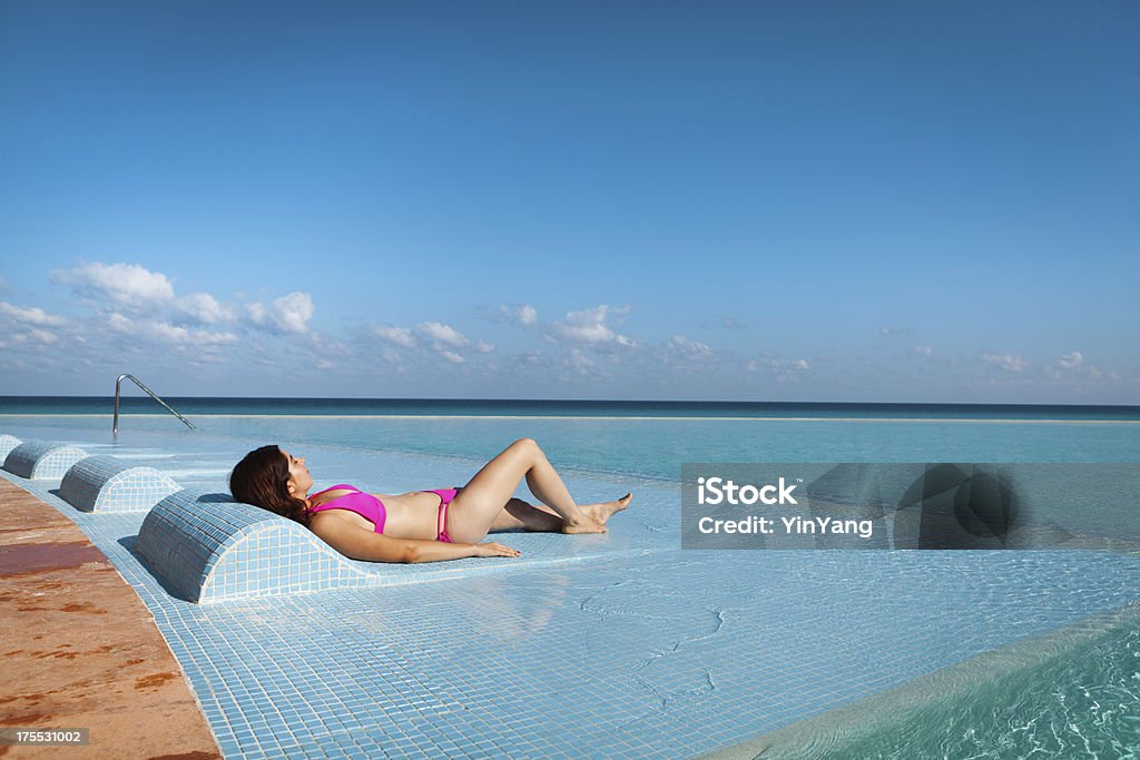 Mujer relajante en piscina de borde infinito, piscina del complejo turístico. - Foto de stock de 20 a 29 años libre de derechos